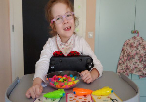 dziewczynka w różowych okularach uczy się liczyć za pomocą balonów , pompki i kart z liczbą